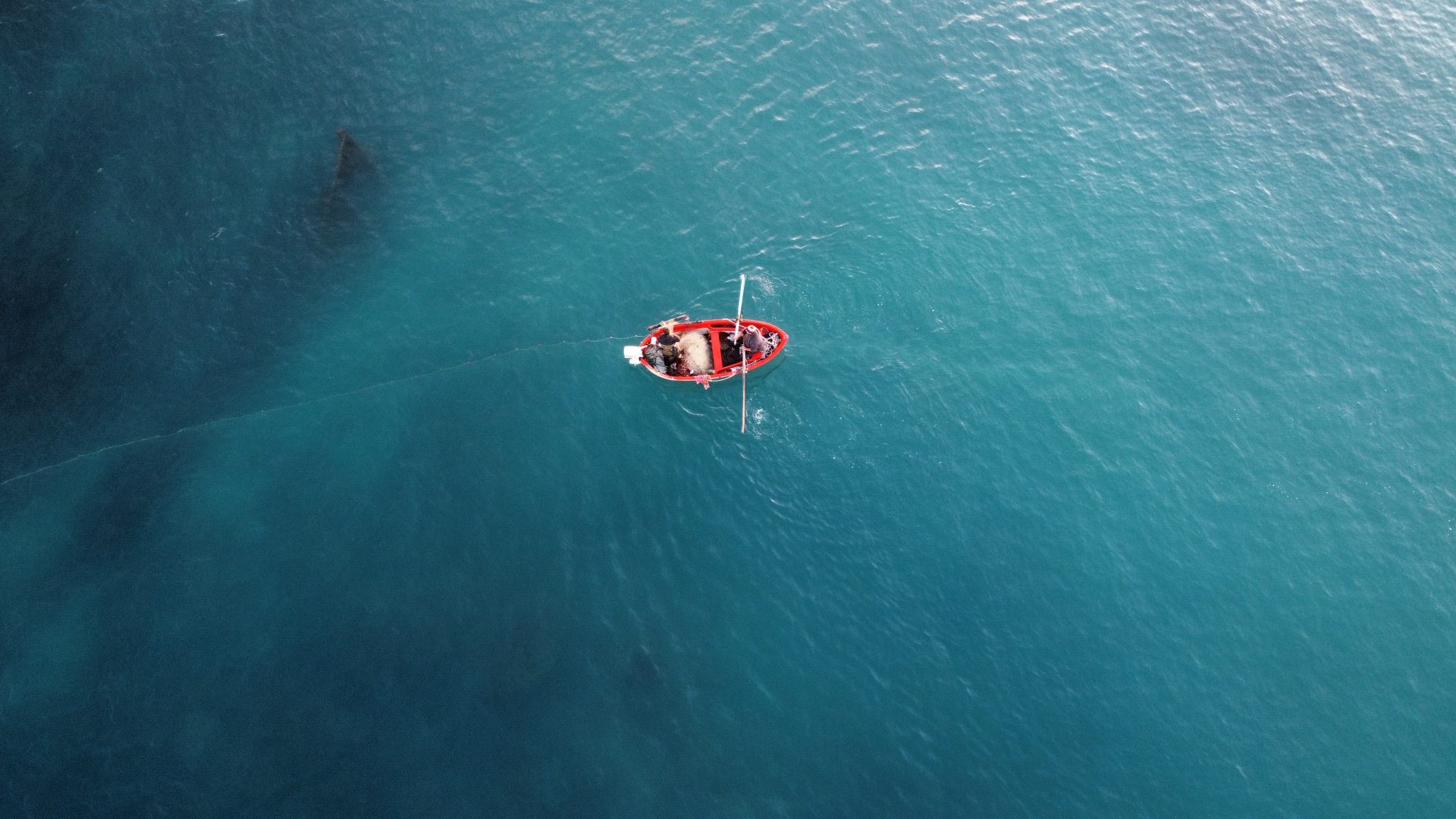 foto aerea piccolo pescatore artigianale che cala le reti nel mar Mediterraneo